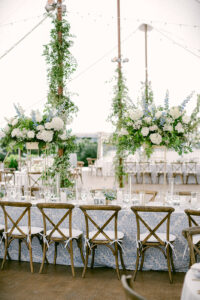 Beautiful green-heavy florals make white linens pop in Maine wedding