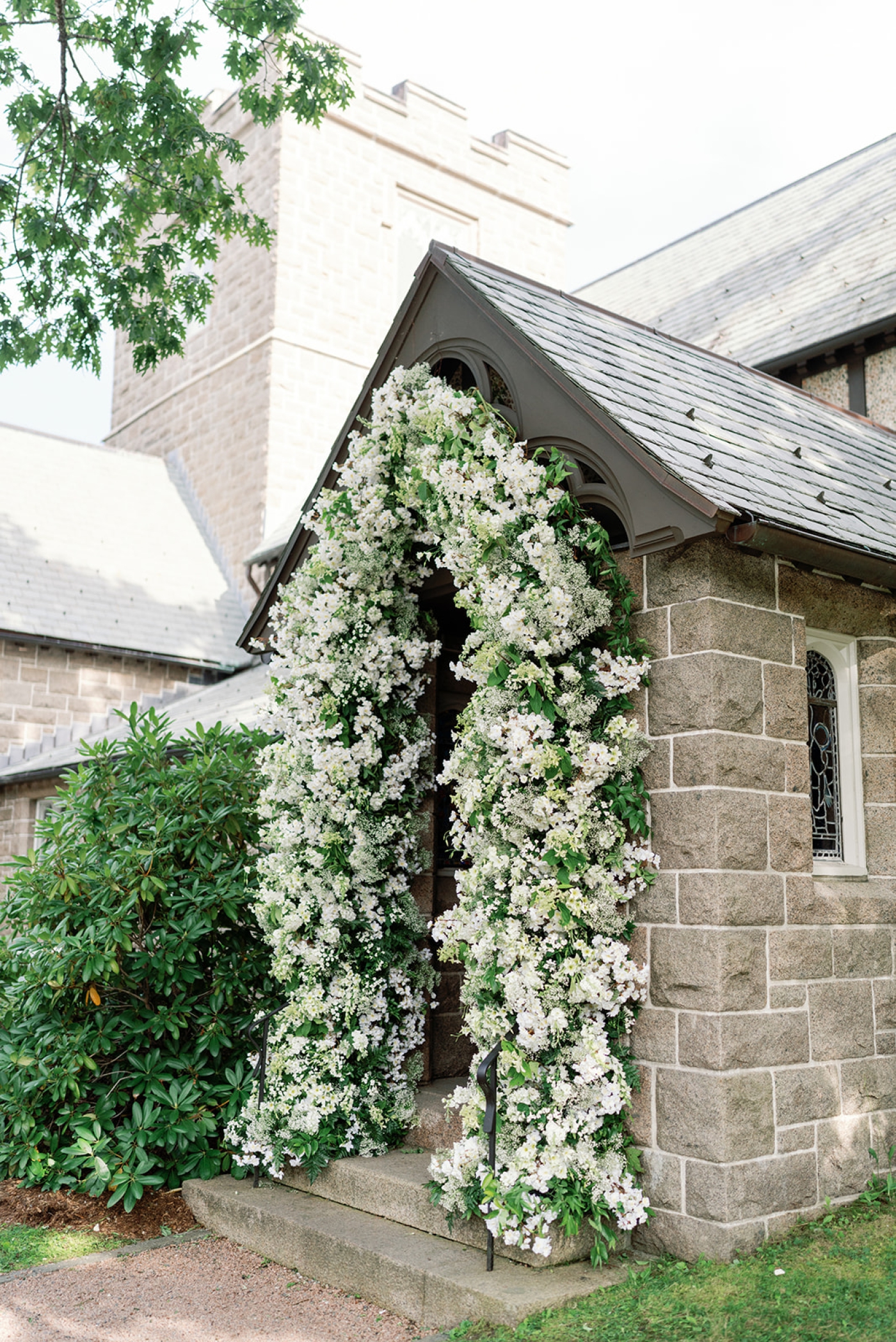 A floral arch of baby's breath, bouvardia, and botanic lisianthus