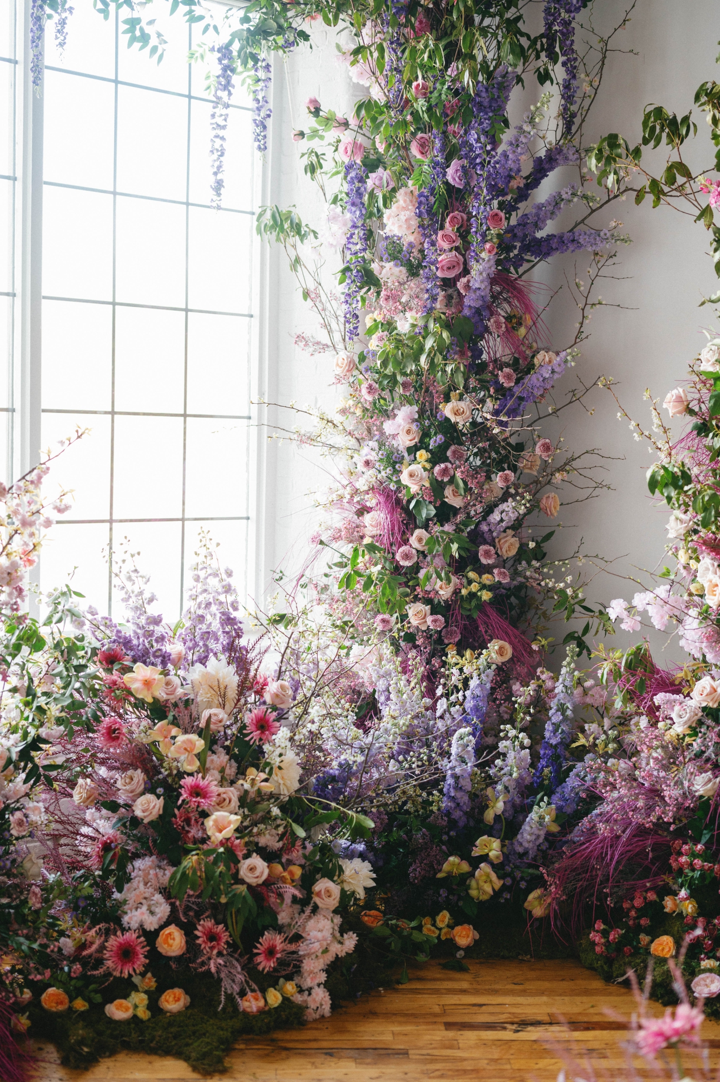 A moody, purple climbing floral arrangement made of sustainable wedding flowers