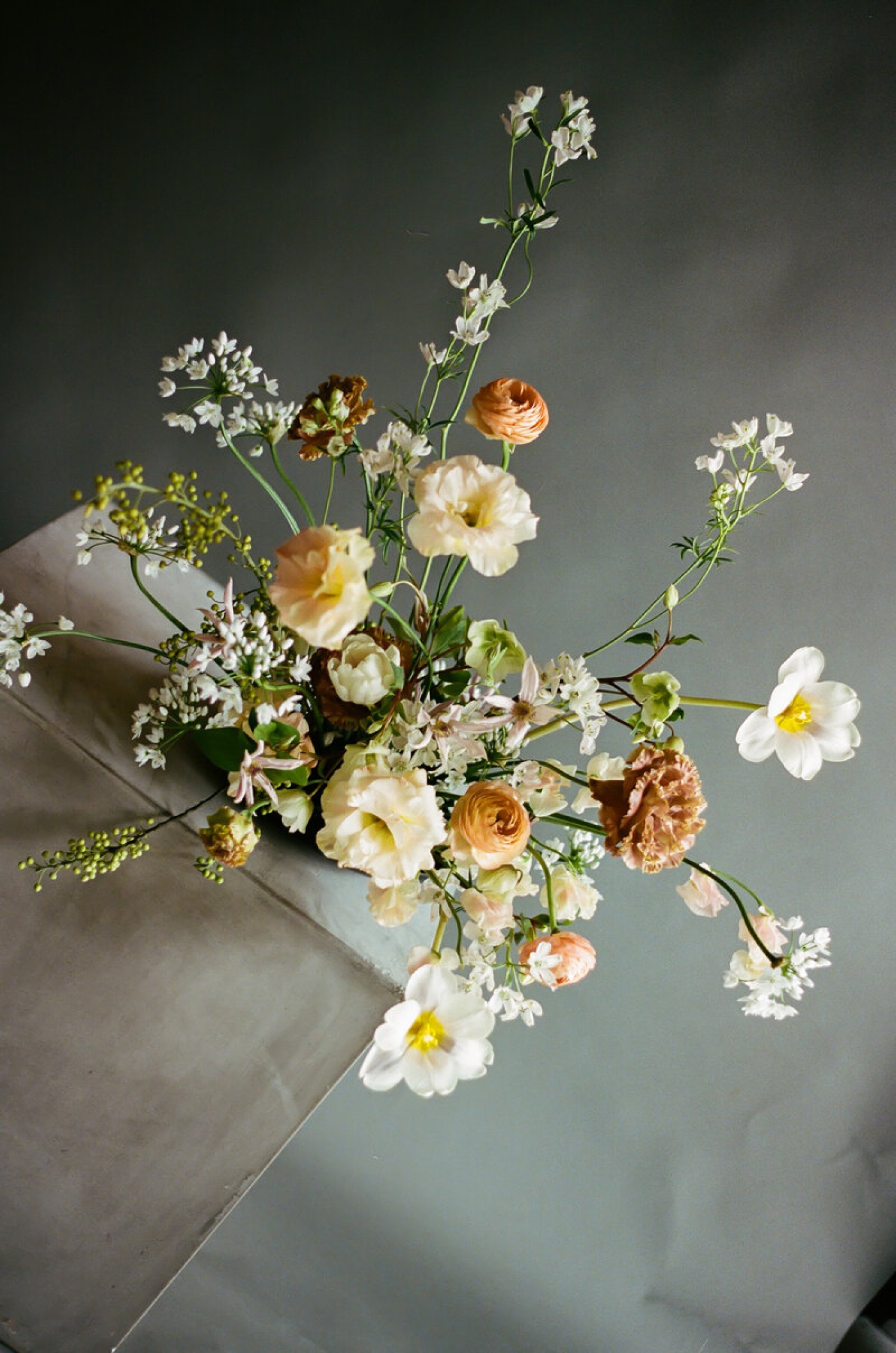 A unique, asymmetrical wedding flower arrangement with white and rust colored blooms