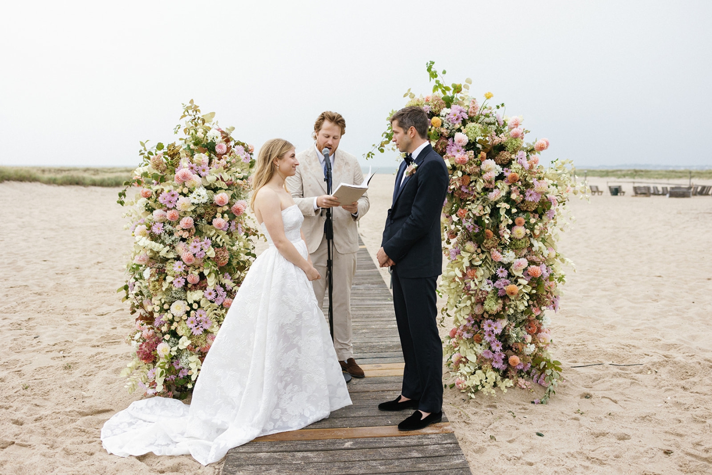 A bride and groom exchange vows on the beach during their wedding at Kalmar Village