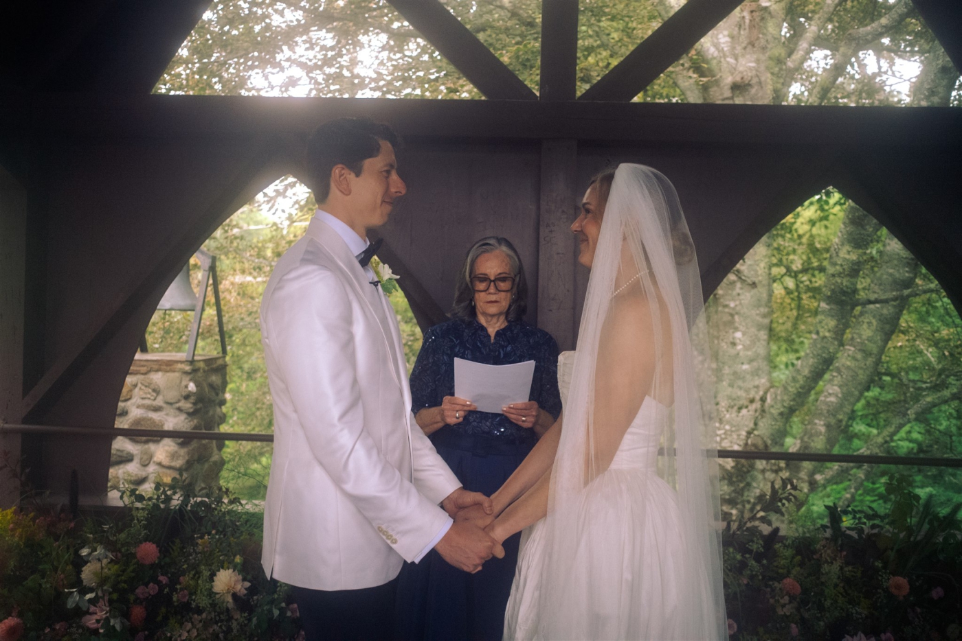 A film photo of a bride and groom holding hands while exchanging vows