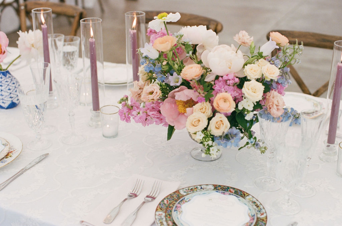 Peony wedding flowers as a centerpiece, next to mismatched china plates 