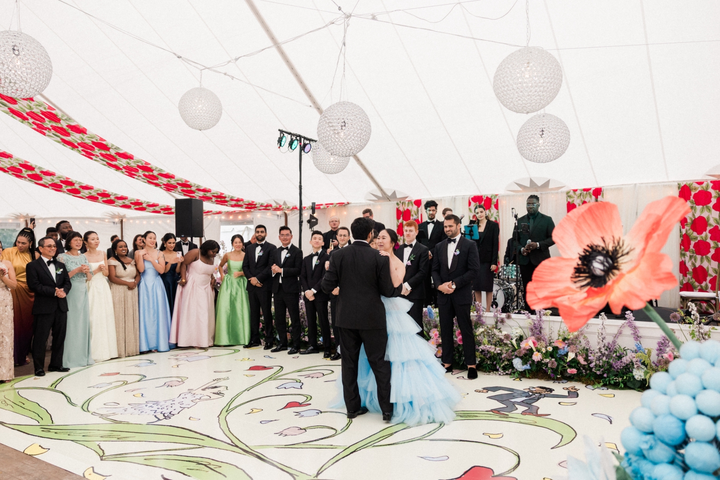 A bride and groom share a dance on a custom dance floor