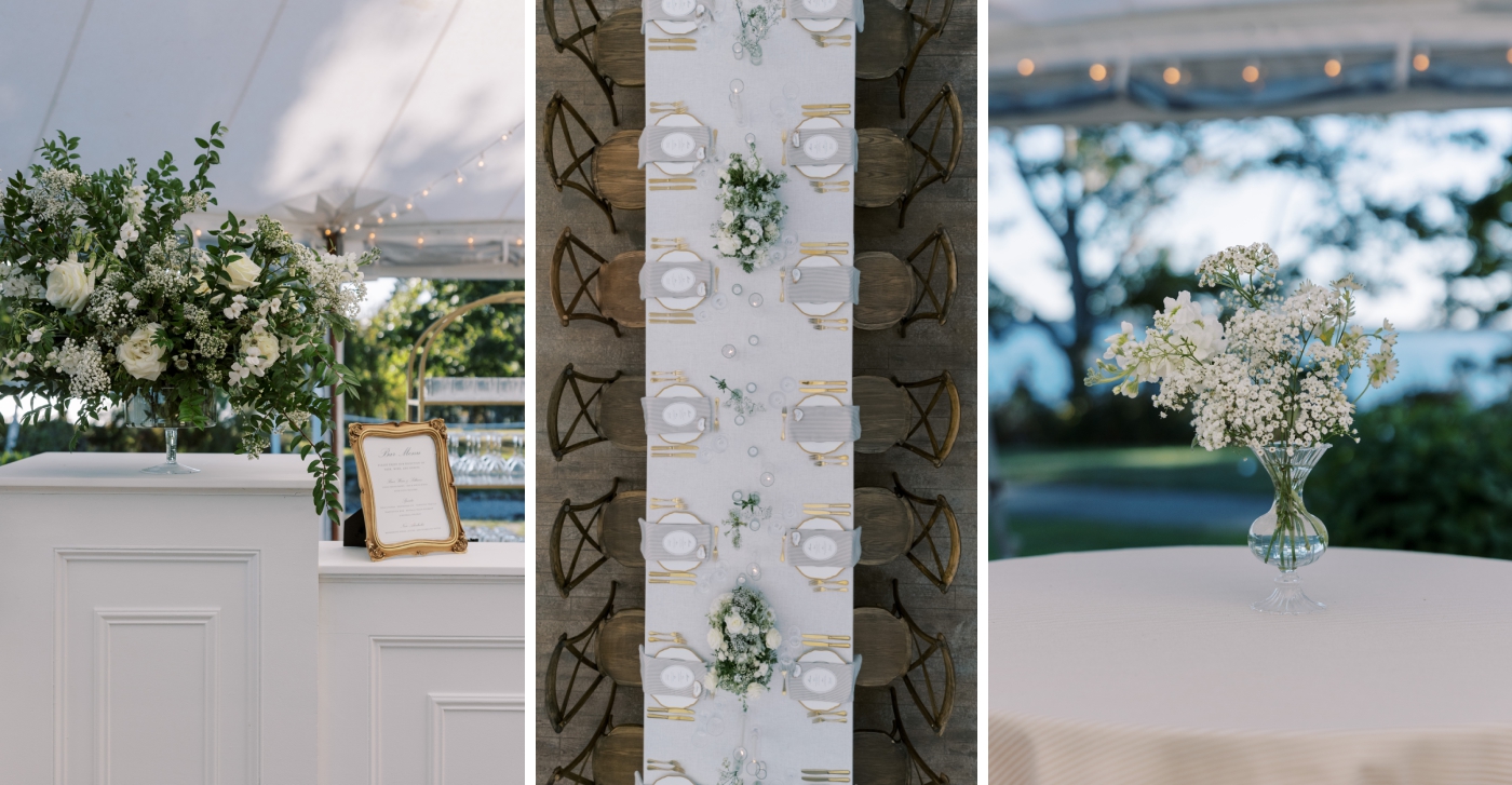 A large floral installations with white flowers sits on a bar in a tented wedding reception